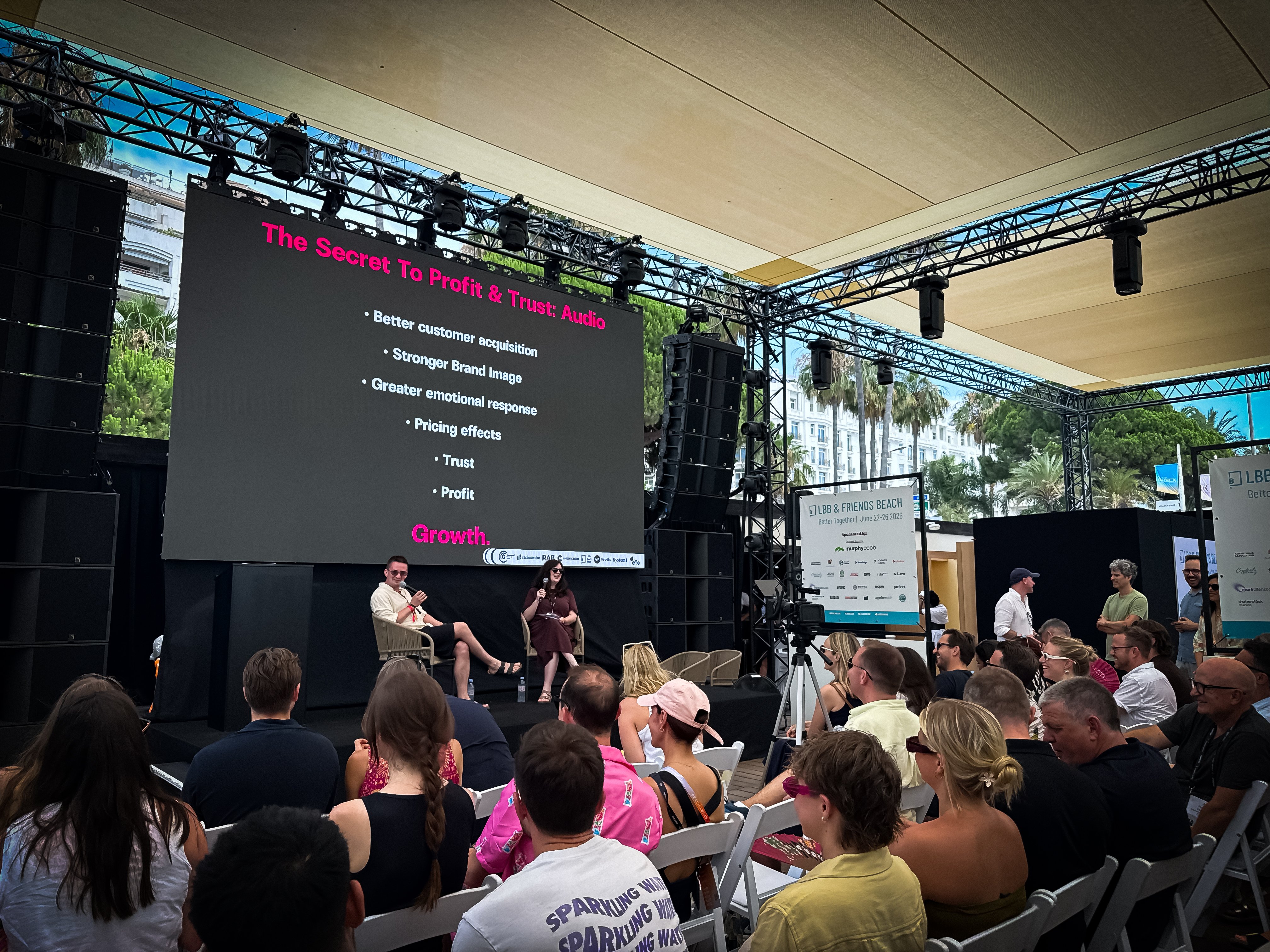 Andrew Tindall of System1 speaking at Cannes Lions 2026 on the beach at Cannes, discussing audio advertising effectiveness research underpinning the global 'Secret to Profit and Trust: Audio' session.